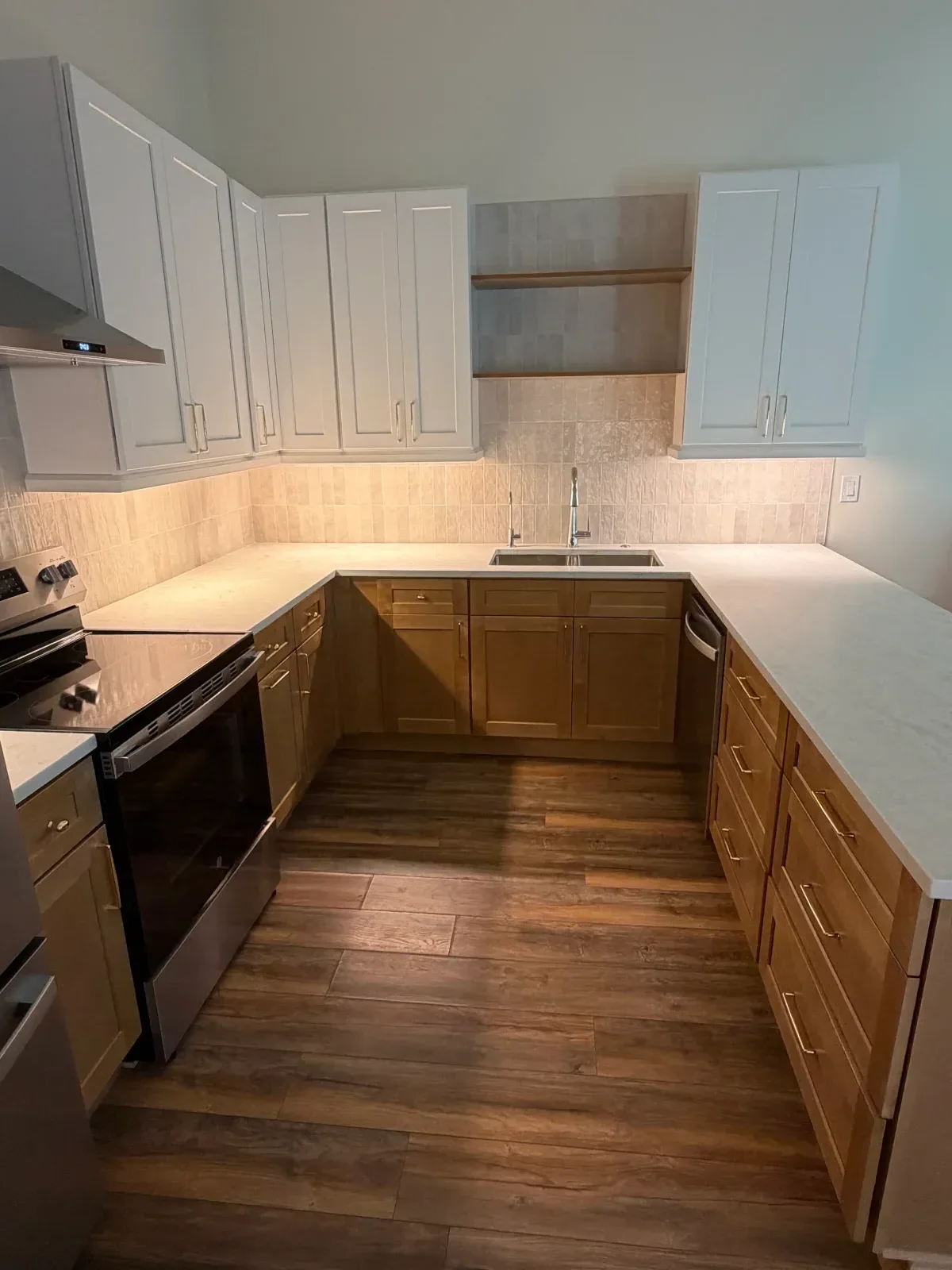 White and walnut kitchen cabinets with shaker doors, brushed nickel hardware, and under-cabinet lighting