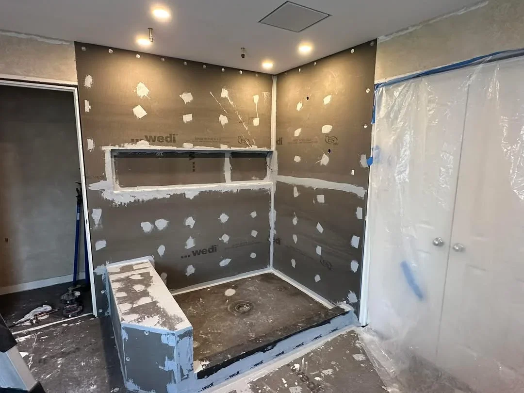 Bathroom shower framing with waterproof membrane, substrate board, and recessed lighting during installation