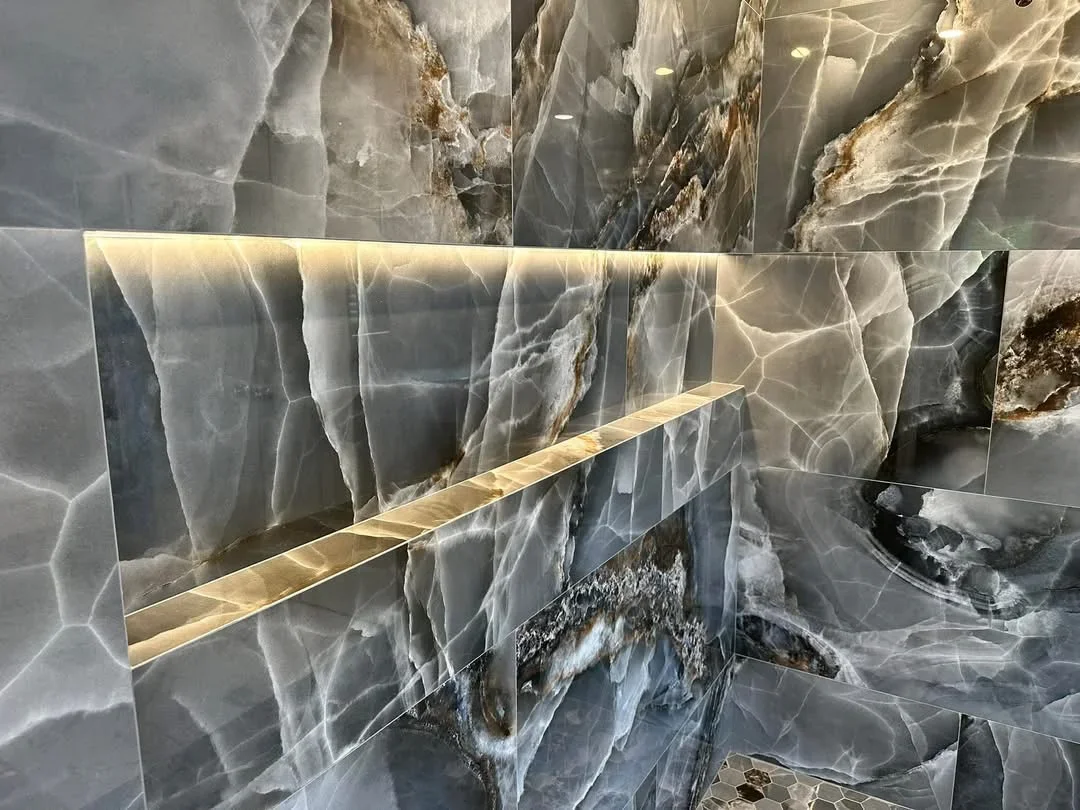 Backlit translucent onyx backsplash with brass trim and natural stone veining