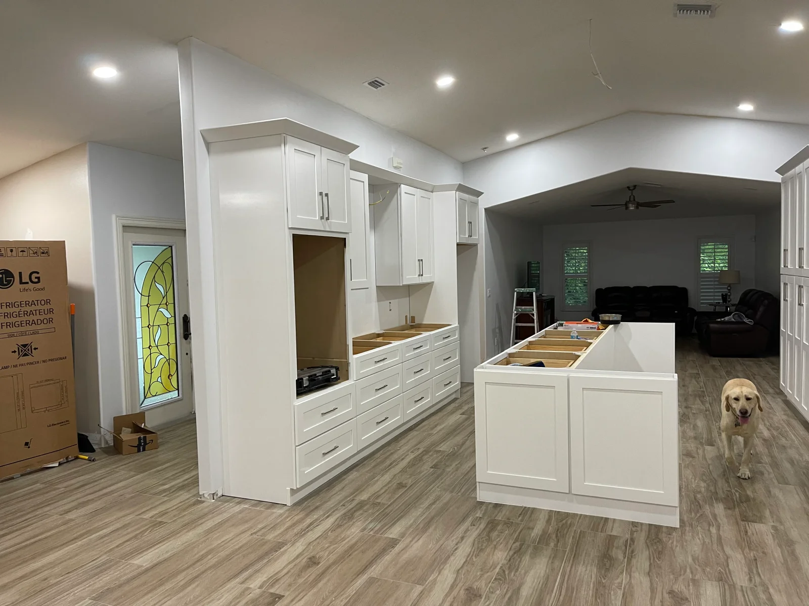 White shaker cabinets, center island, and vinyl plank flooring in newly installed kitchen